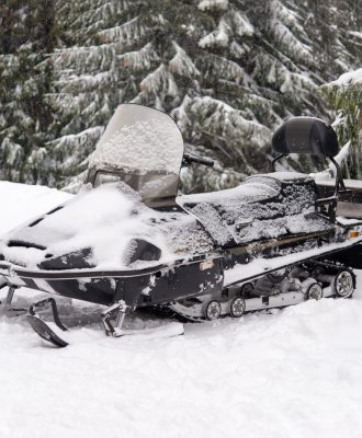 Snowmobile in a snowy landscape. Sports snowmobile in the mountains. Winter transport